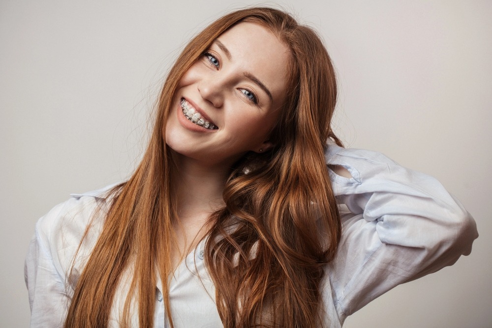 happy young red haired woman in clear braces smiling - Alternatives to Braces in Chester Springs, PA