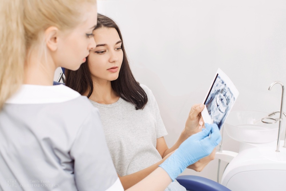 a woman checking her x-ray result as one of the procedures of how to fix overbite in Chester Springs, pa