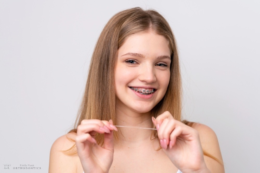 teenager russian girl with metal braces and floss isolated white background - How to Floss with Braces in Chester Springs, PA